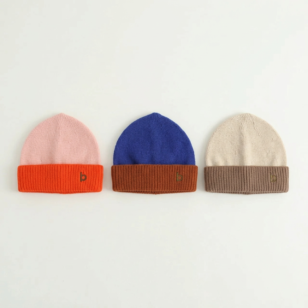 Three Bunzi two-tone knitted beanie color options with embroidered logos laid flat on white