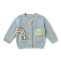 Baby blue knitted cardigan with rainbow and sun pocket details laid flat on white