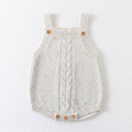 Front view of ivory multicolor-flecked cable-knit baby romper laid flat on white